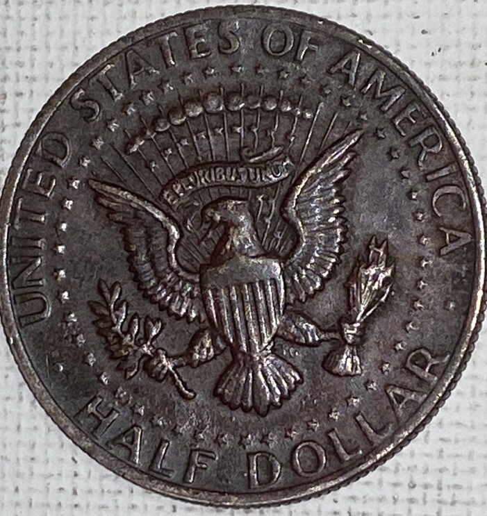 1994 Kennedy half dollar missing clad layer error showing exposed copper core on the obverse face