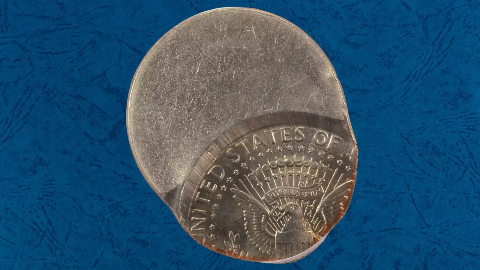 1994 Kennedy half dollar off-center strike error showing crescent-shaped blank and design shifted significantly from center